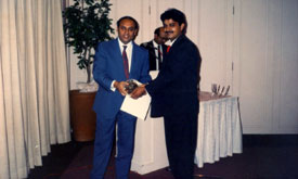 Rajan Sachdev receiving award from Executive Director Modi GBC during an awards night in Singapore.