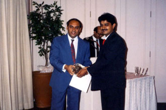 Rajan Sachdev receiving award from Executive Director Modi GBC during an awards night in Singapore.